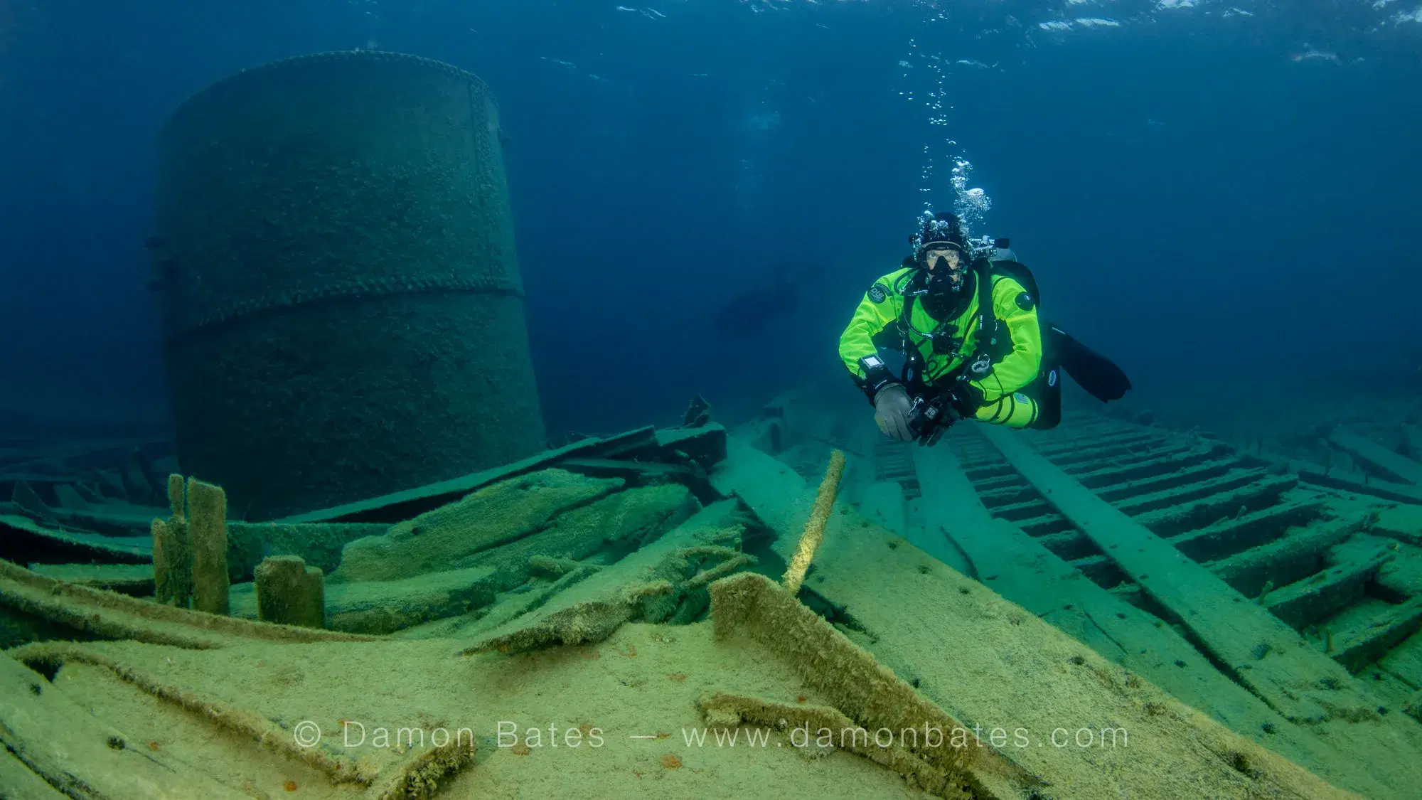 Scuba diver beside the boiler of the Wetmore wreck with preserved wooden deck in the foreground, Lake Huron, Tobermory, Ontario — underwater photograph by Damon Bates