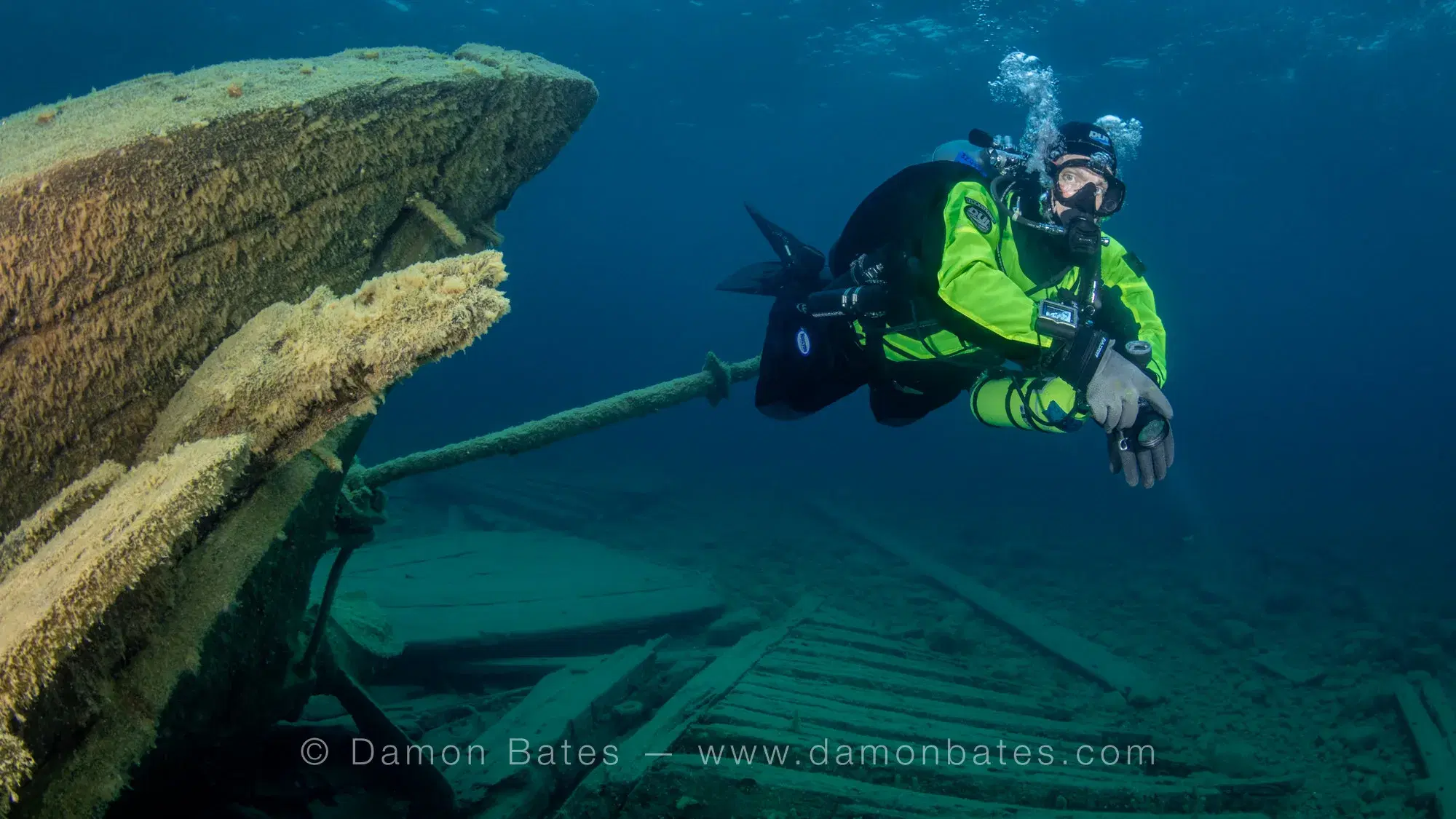 Scuba diver alongside the bowsprit of the Wetmore wreck, Lake Huron, Tobermory, Ontario — underwater photograph by Damon Bates