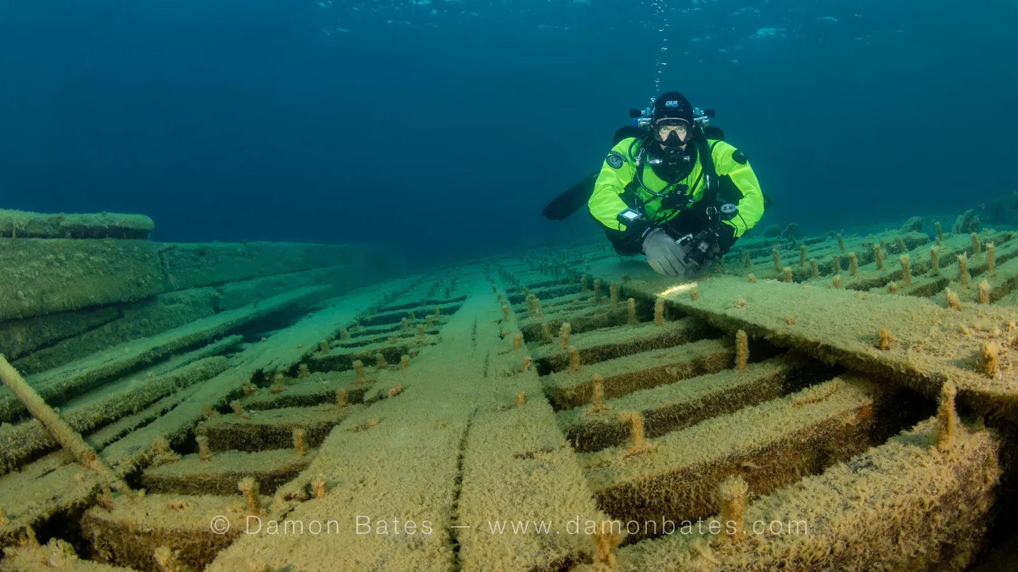 Scuba diver over the preserved wooden deck planks of the Wetmore wreck, Lake Huron, Tobermory, Ontario — underwater photograph by Damon Bates