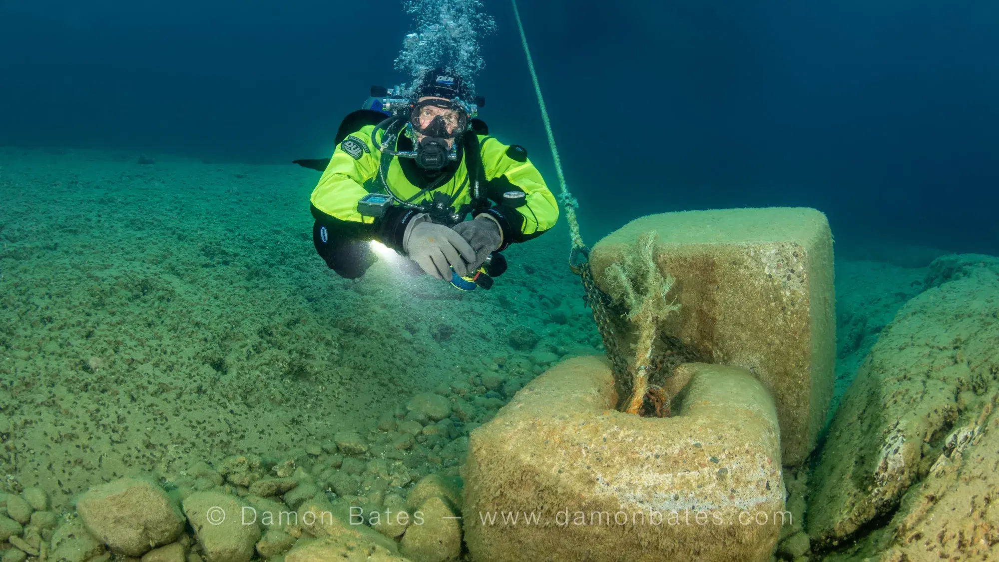 Scuba diver examining a stone anchor on the lakebed beside the Wetmore wreck, Lake Huron, Tobermory, Ontario — underwater photograph by Damon Bates