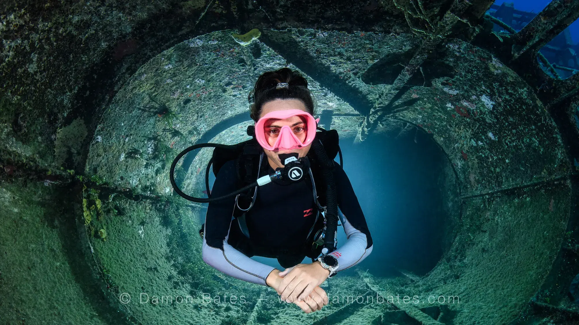 Scuba diver framed inside the funnel of the USS Kittiwake, Grand Cayman, 2025 — underwater photograph by Damon Bates